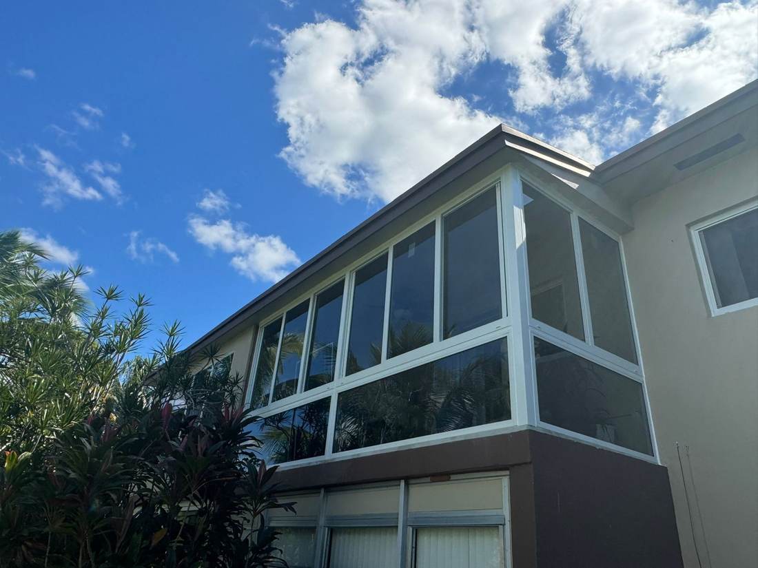 Condo balcony enclosed with new white-frame impact windows