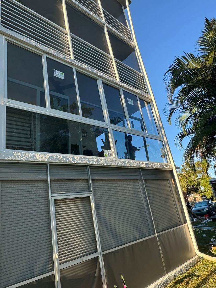 Mid-rise condo balcony with new impact windows being installed