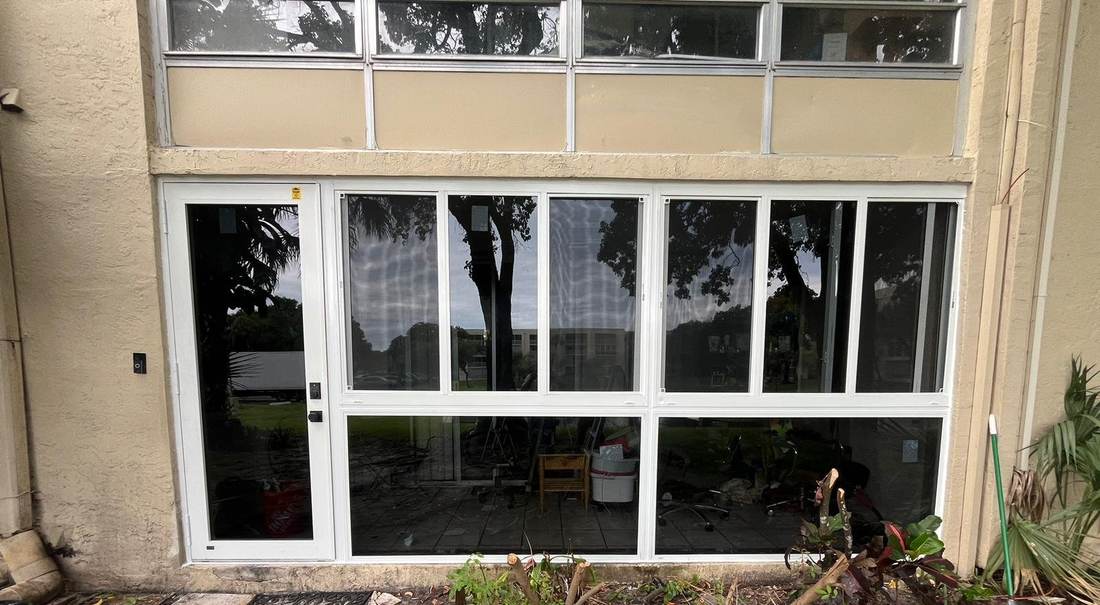 Ground-floor condo unit with a new white-frame impact window wall and entry door