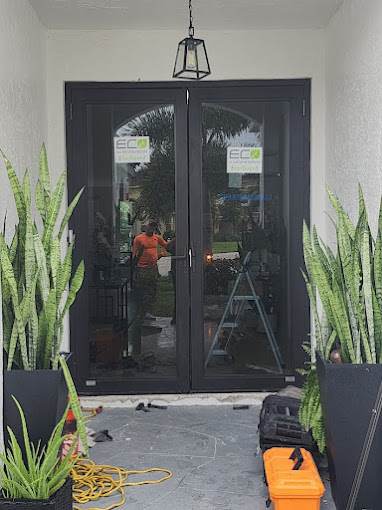 Black-frame impact French doors with arched glass at a home entry