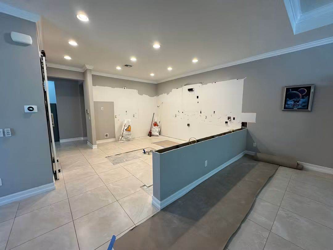 Kitchen during demolition with cabinets removed and walls stripped