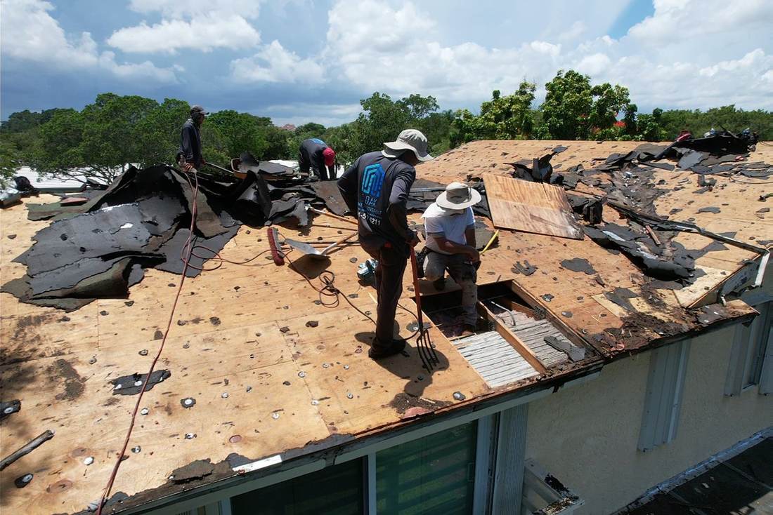 Roofers replacing a section of rotted roof decking during a re-roof